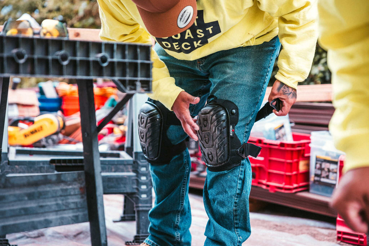 [First name], tile setter, adjusting the thigh strap on the leg, buckle and strap length visible, work pants, head in frame. Callout: "adjustable both sides".