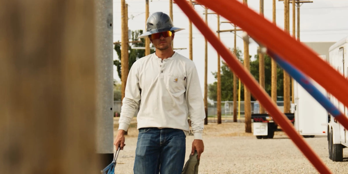 Tile setter mid-shift, on both knees on a half-laid floor, GelGuard Pro on the knee, grout on hands, head in frame, eyes on the work.