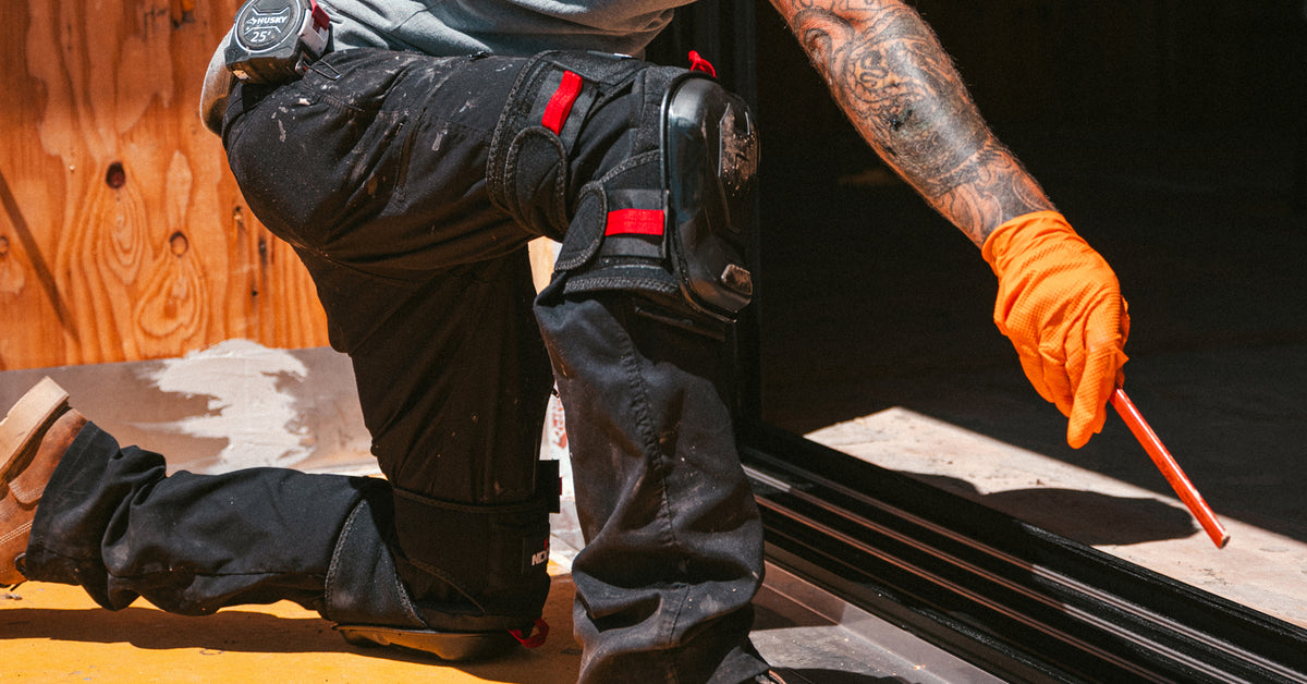 [First name], tile setter, adjusting the thigh strap on the leg, buckle and strap length visible, work pants, head in frame. Callout: "adjustable both sides".